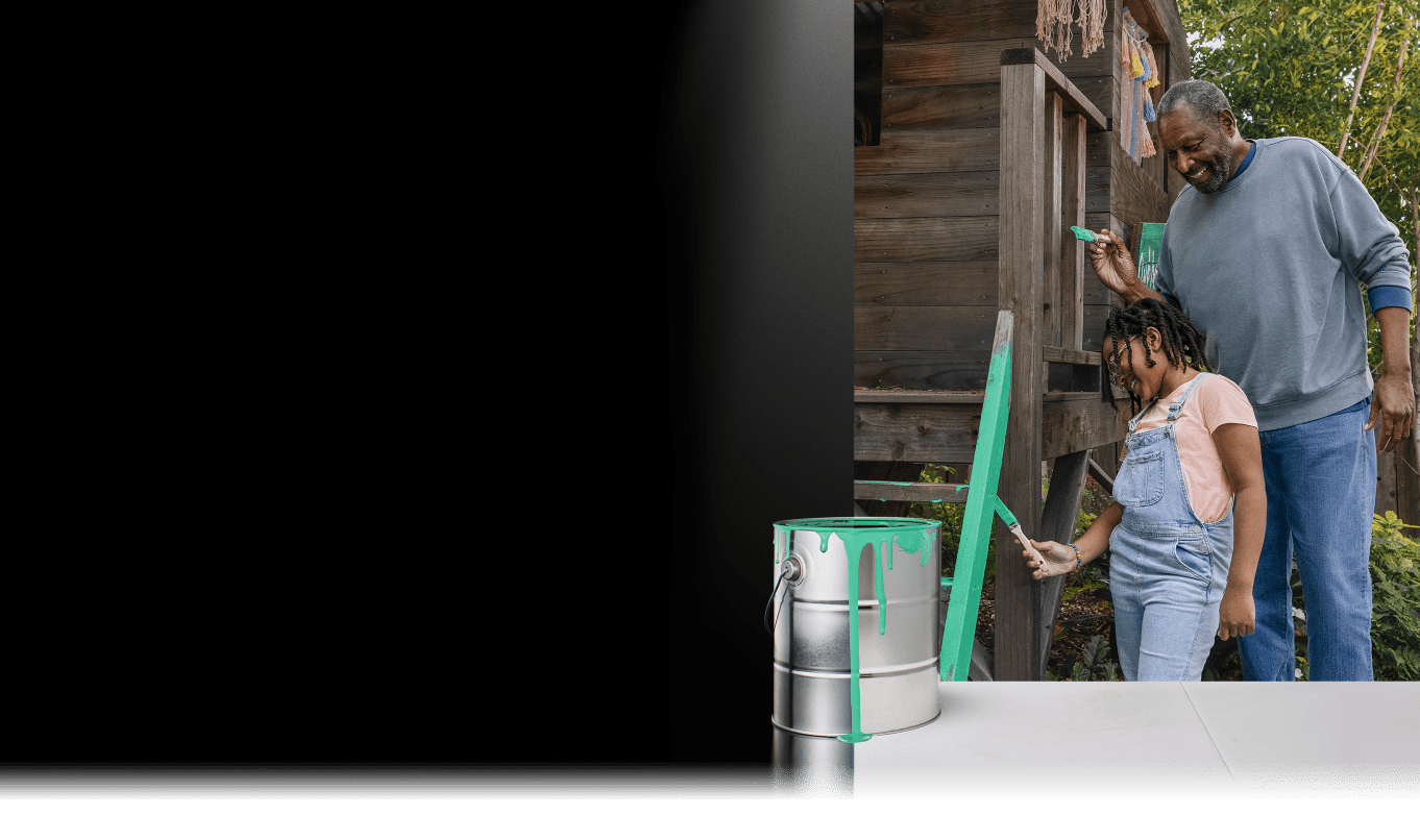 Man with his child painting a treehouse
