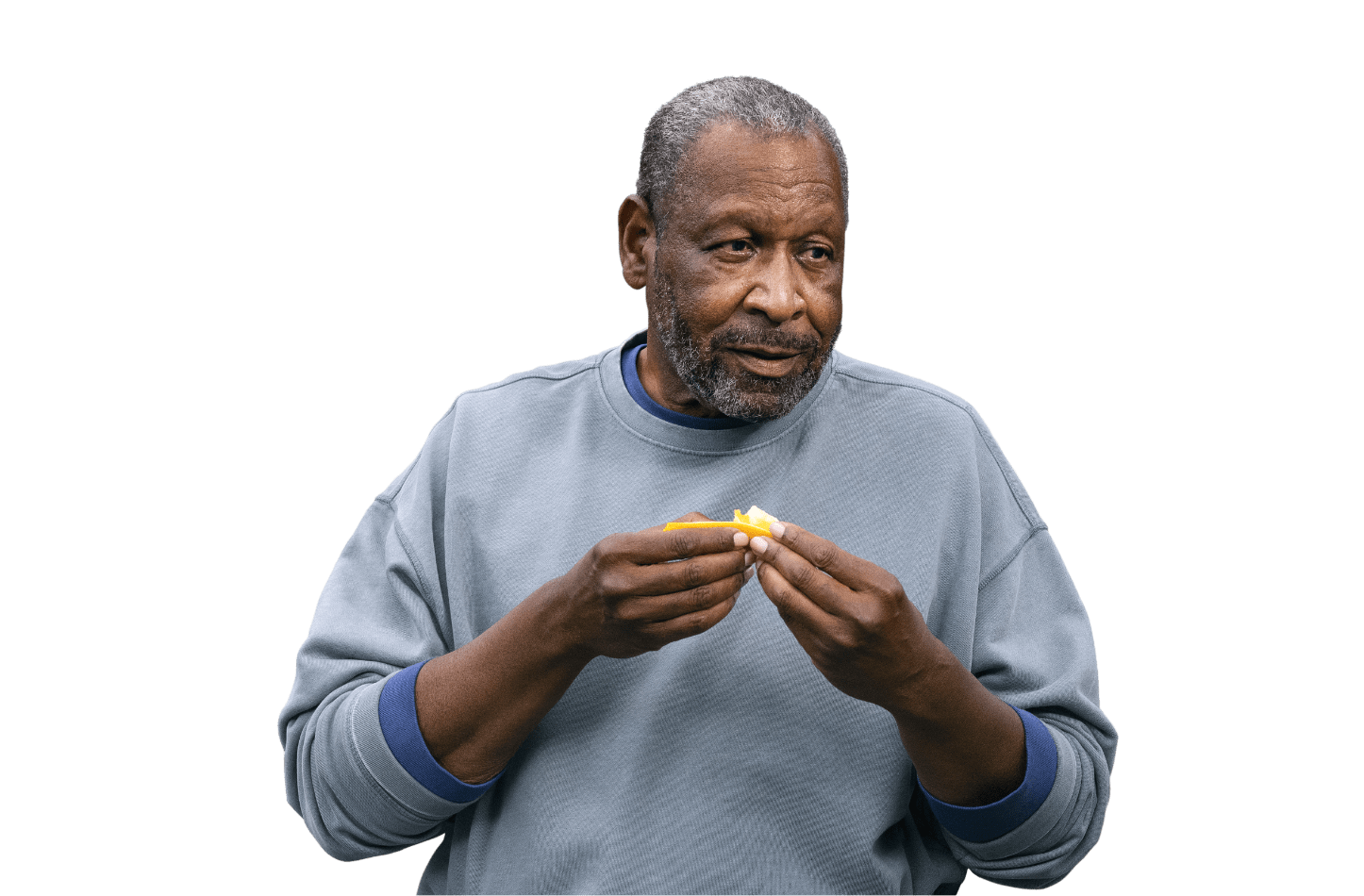 Man in sweater eating an orange