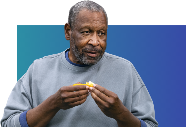 Man in sweater eating an orange